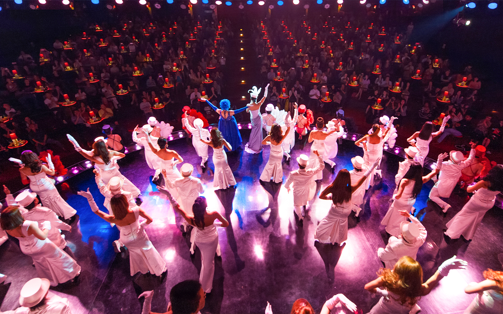 Performers in vibrant costumes on stage at Calypso Cabaret Show, Bangkok.