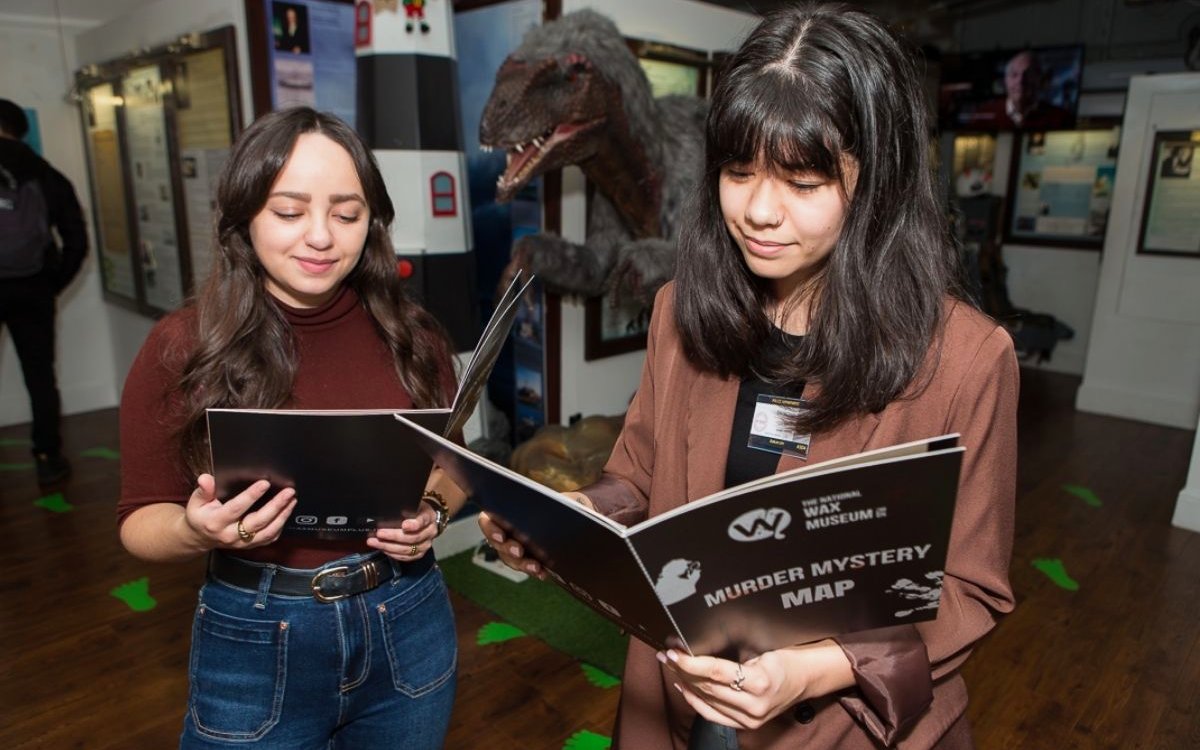 Visitors reading a Murder Mystery map at the National Wax Museum Plus.