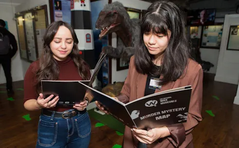 Visitors reading a Murder Mystery map at the National Wax Museum Plus.
