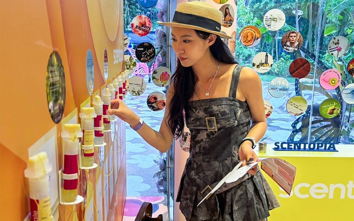 Woman exploring fragrance samples at Scentopia Sentosa.