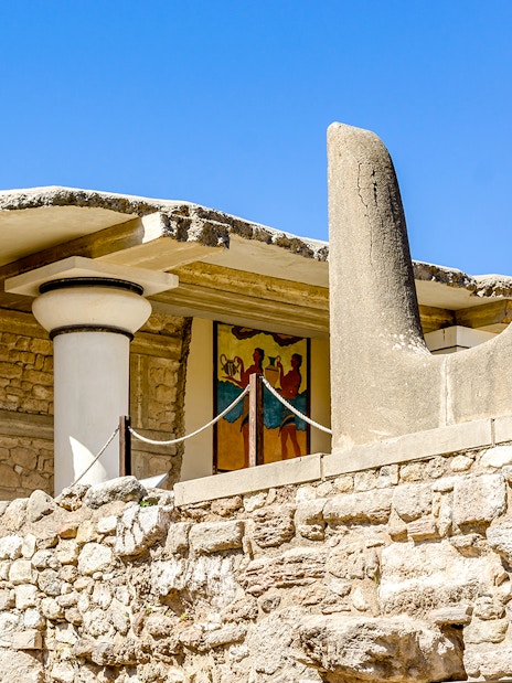 Bulls Horns sculpture at Knossos Palace, Crete, with ancient fresco in background.