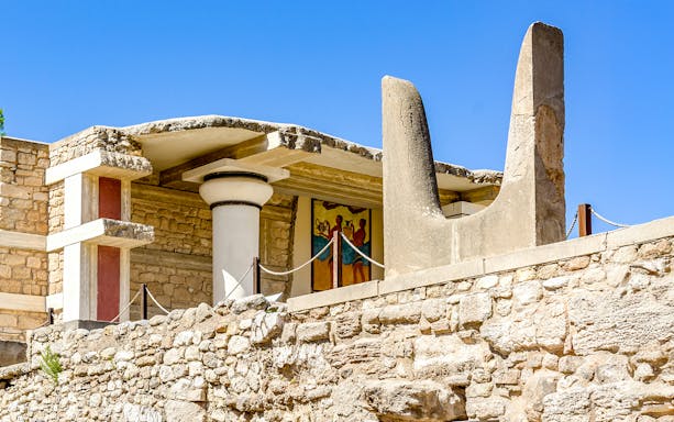 Bulls Horns sculpture at Knossos Palace, Crete, with ancient fresco in background.