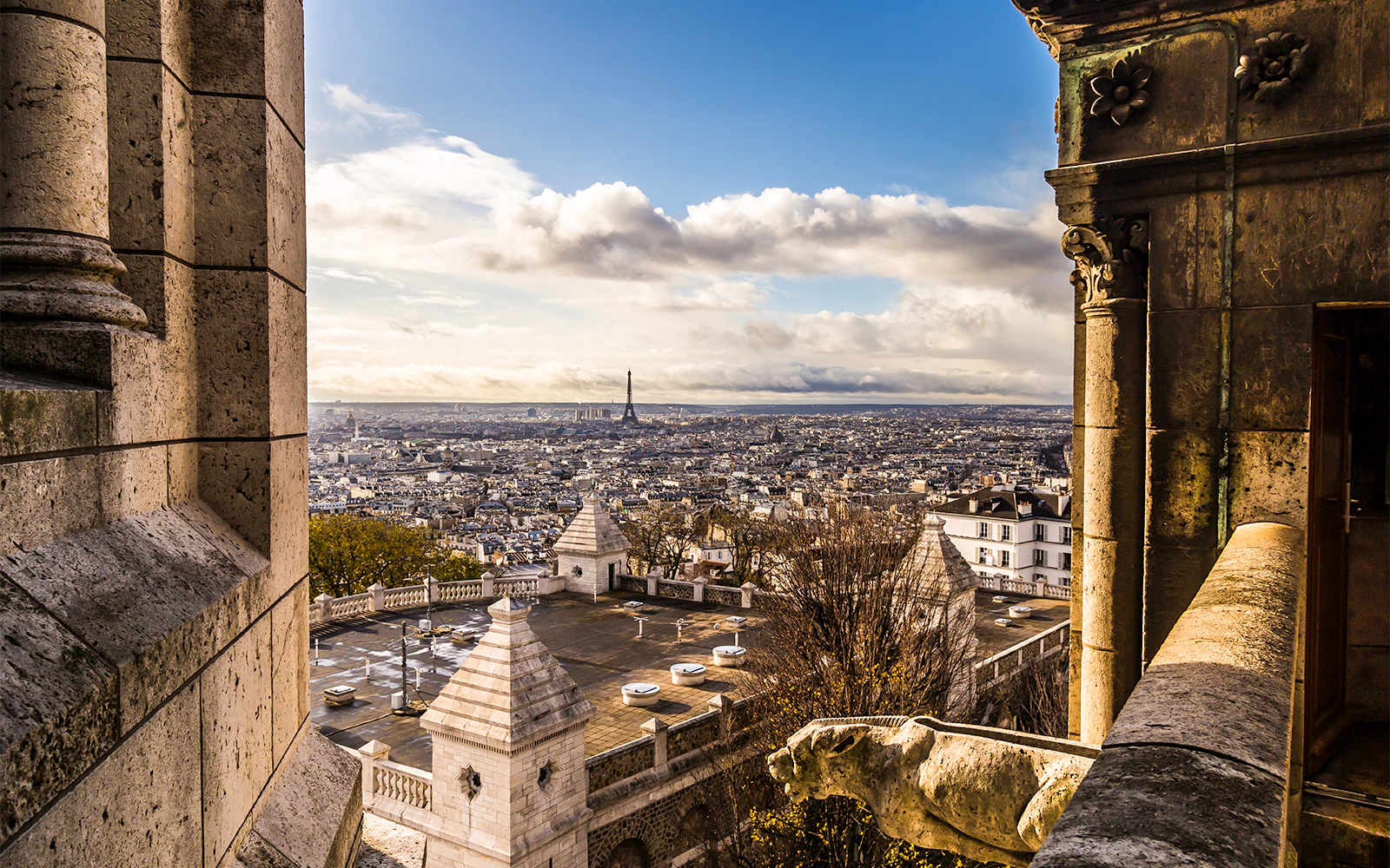 View of Paris skyline from Sacré Coeur Basilica, featuring Eiffel Tower in the distance.