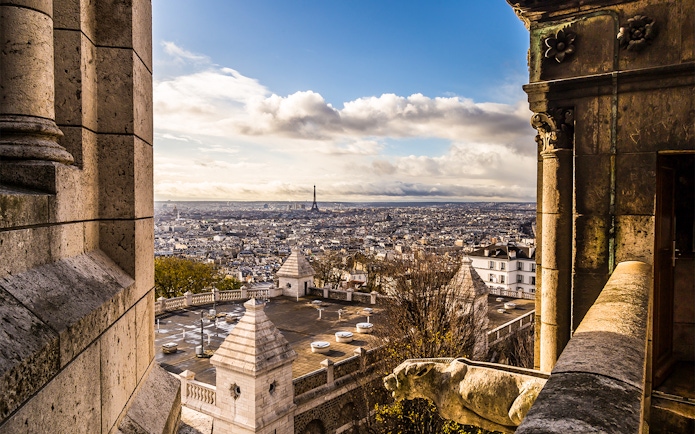 View of Paris skyline from Sacré Coeur Basilica, featuring Eiffel Tower in the distance.