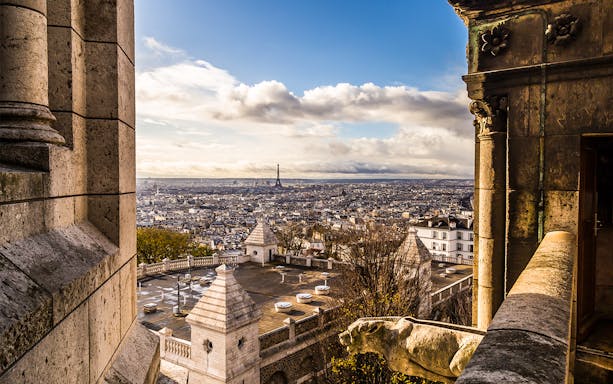 View of Paris skyline from Sacré Coeur Basilica, featuring Eiffel Tower in the distance.