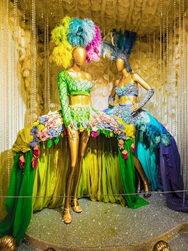 Mannequins in vibrant Broadway costumes at the Museum of Broadway exhibit.