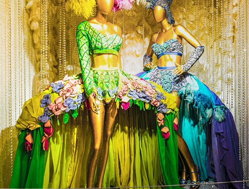 Mannequins in vibrant Broadway costumes at the Museum of Broadway exhibit.