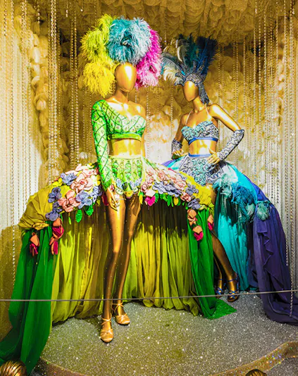Mannequins in vibrant Broadway costumes at the Museum of Broadway exhibit.