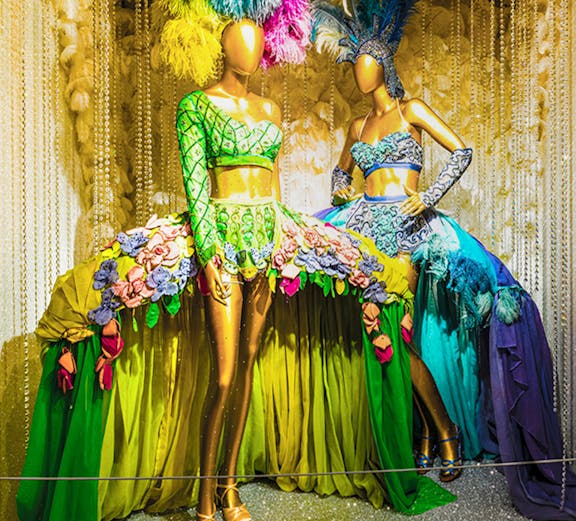 Mannequins in vibrant Broadway costumes at the Museum of Broadway exhibit.