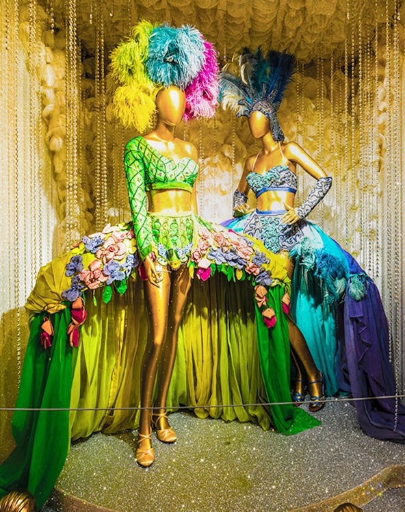 Mannequins in vibrant Broadway costumes at the Museum of Broadway exhibit.