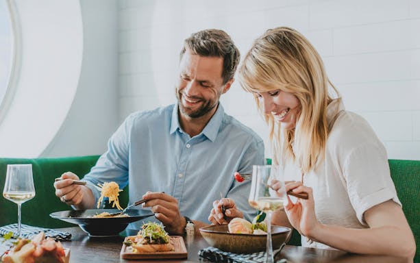 Couple enjoying breakfast on an overnight ferry to Helsinki.