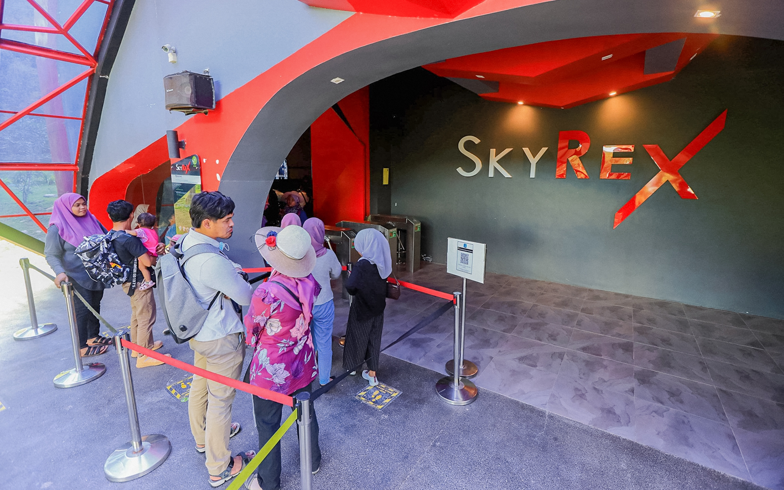 Tourists waiting in line at the entrance of SkyRex attraction.