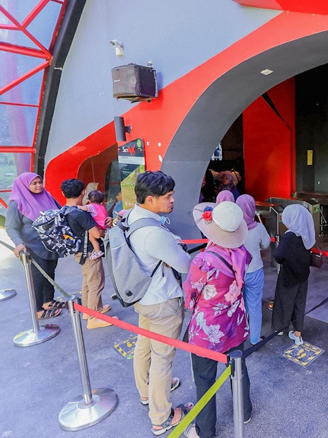 Tourists waiting in line at the entrance of SkyRex attraction.