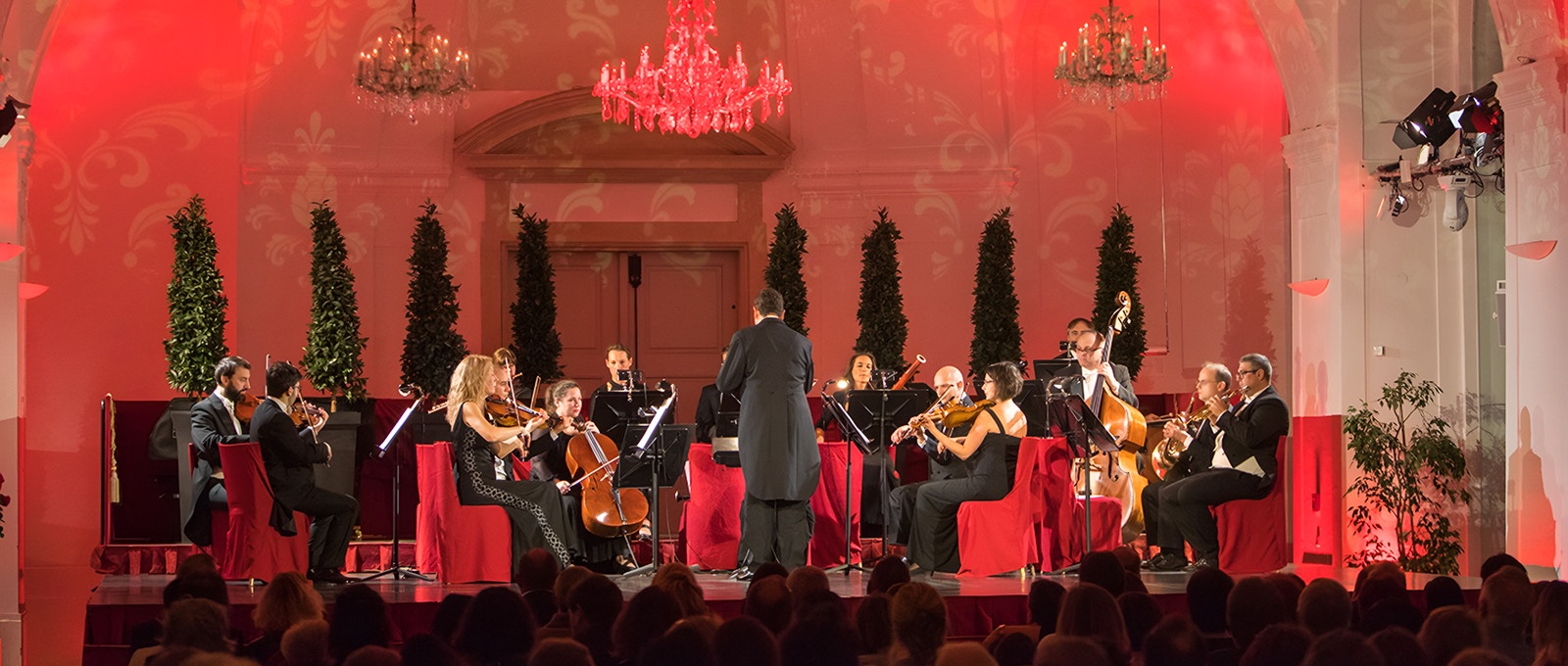 Schönbrunn Palace concert hall with musicians performing Mozart and Strauss pieces in Vienna, Austria.