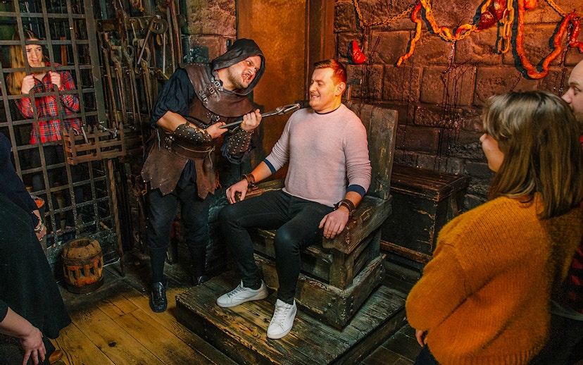 Visitors in the Torture Chamber at Harry Potter Warner Bros. Studio Tour, London Dungeon combo.
