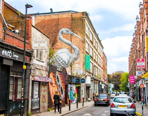 Street art and shops on Brick Lane, London, part of the Shoreditch food tour.