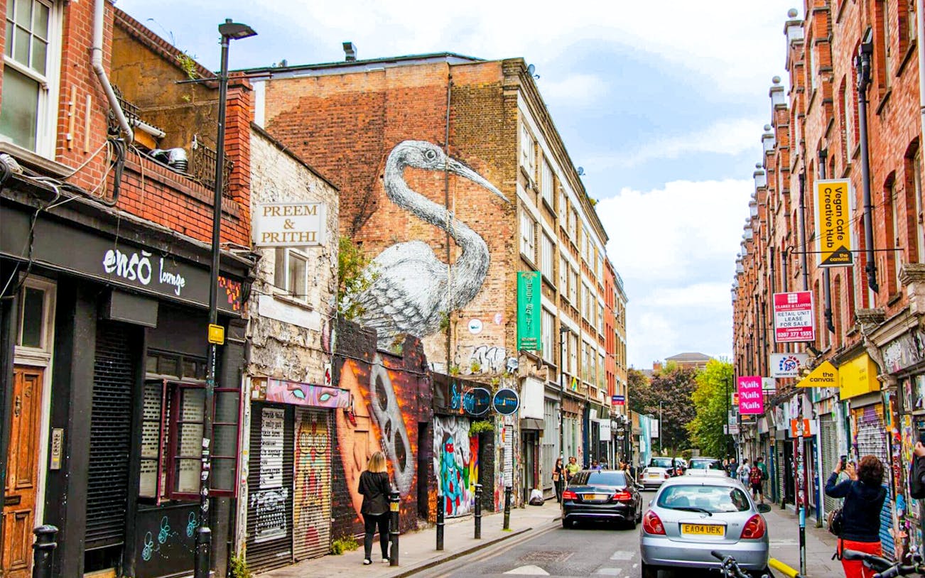Street art and shops on Brick Lane, London, part of the Shoreditch food tour.