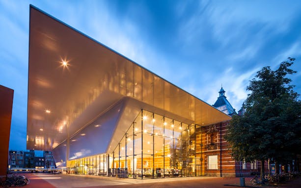 Stedelijk Museum entrance with modern architecture in Amsterdam at dusk.