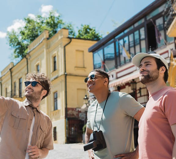 Tourists exploring a historic street with yellow buildings in a European city.