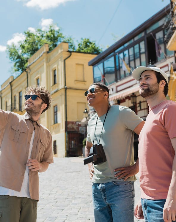 Tourists exploring a historic street with yellow buildings in a European city.