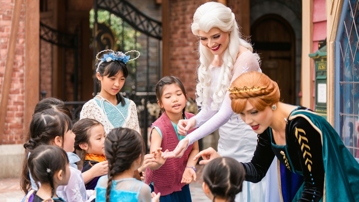 Elsa and Anna interacting with children at Disneyland Hong Kong's Frozen Ever After attraction.