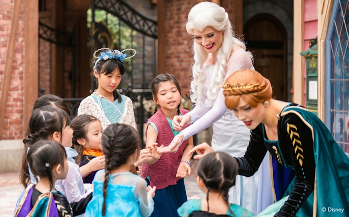 Elsa and Anna interacting with children at Disneyland Hong Kong's Frozen Ever After attraction.