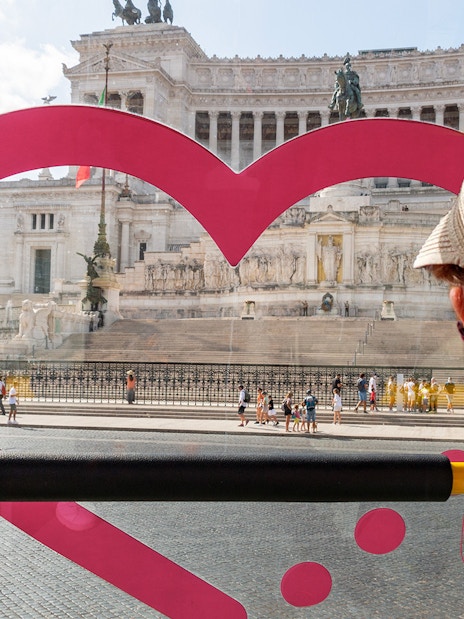 Child on Rome hop-on hop-off bus tour viewing Altare della Patria with kids audioguide.