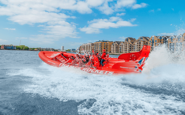 Speed boat on the Thames River with passengers enjoying the ride, London.
