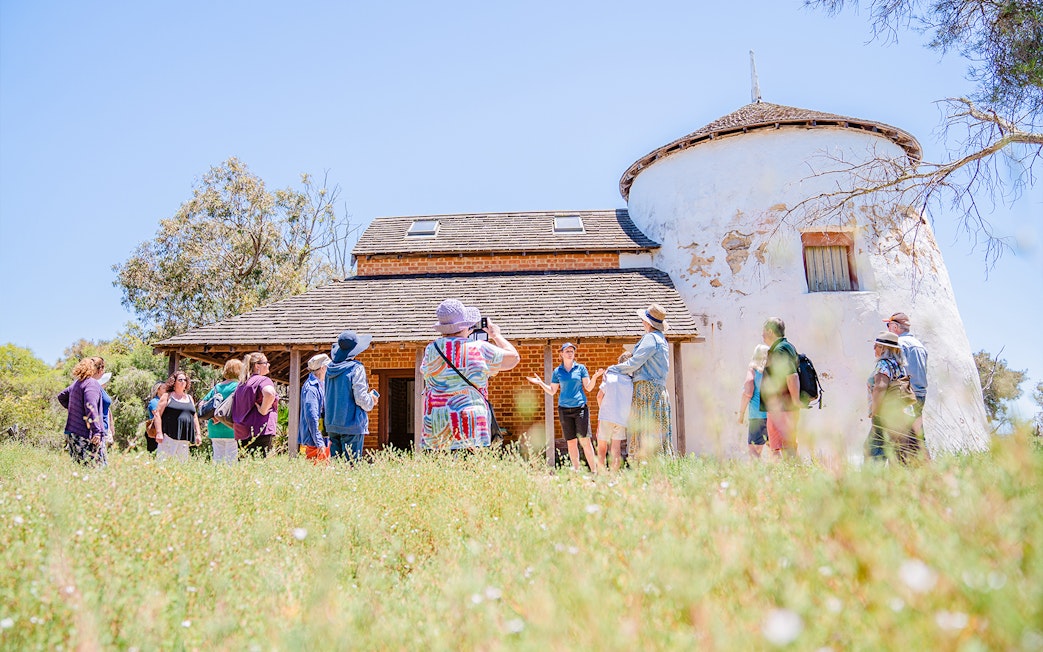 Tour group exploring historic building on Murray River Lunch Cruise.