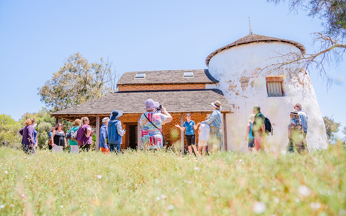 Tour group exploring historic building on Murray River Lunch Cruise.