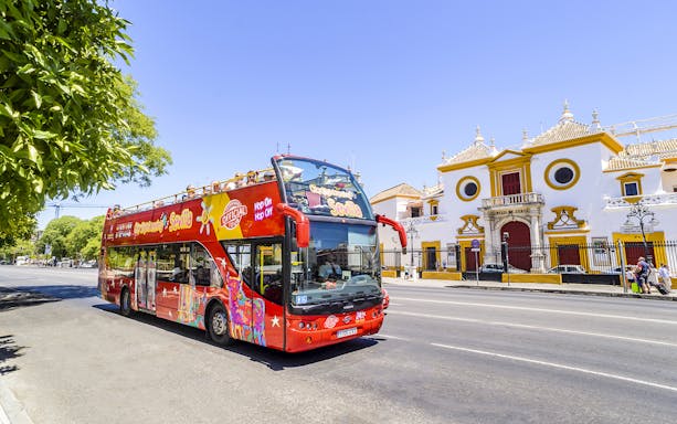 Seville hop-on hop-off bus passing by the Plaza de Toros in Seville, Spain.