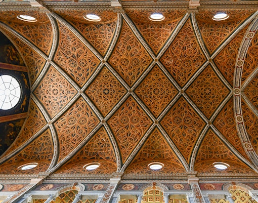 Gothic architecture style ceiling with intricate ribbed vaults in a historic European cathedral.