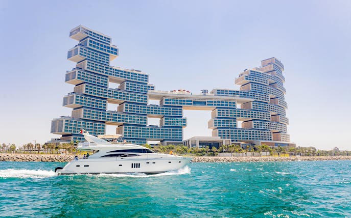 Yacht cruising near Atlantis The Royal in Dubai during luxury tour with BBQ and drinks.