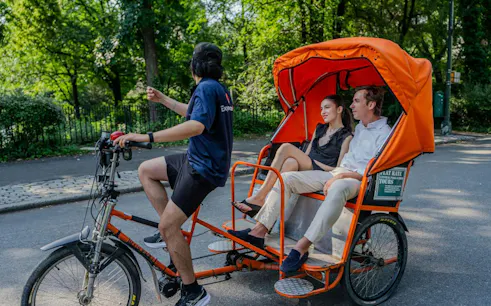 Pedicab ride through Central Park, New York with two passengers enjoying the tour.