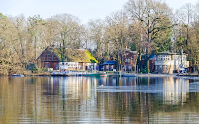 Ferry docked at Island Scharfenberg in Berlin with historic buildings and trees in the background.