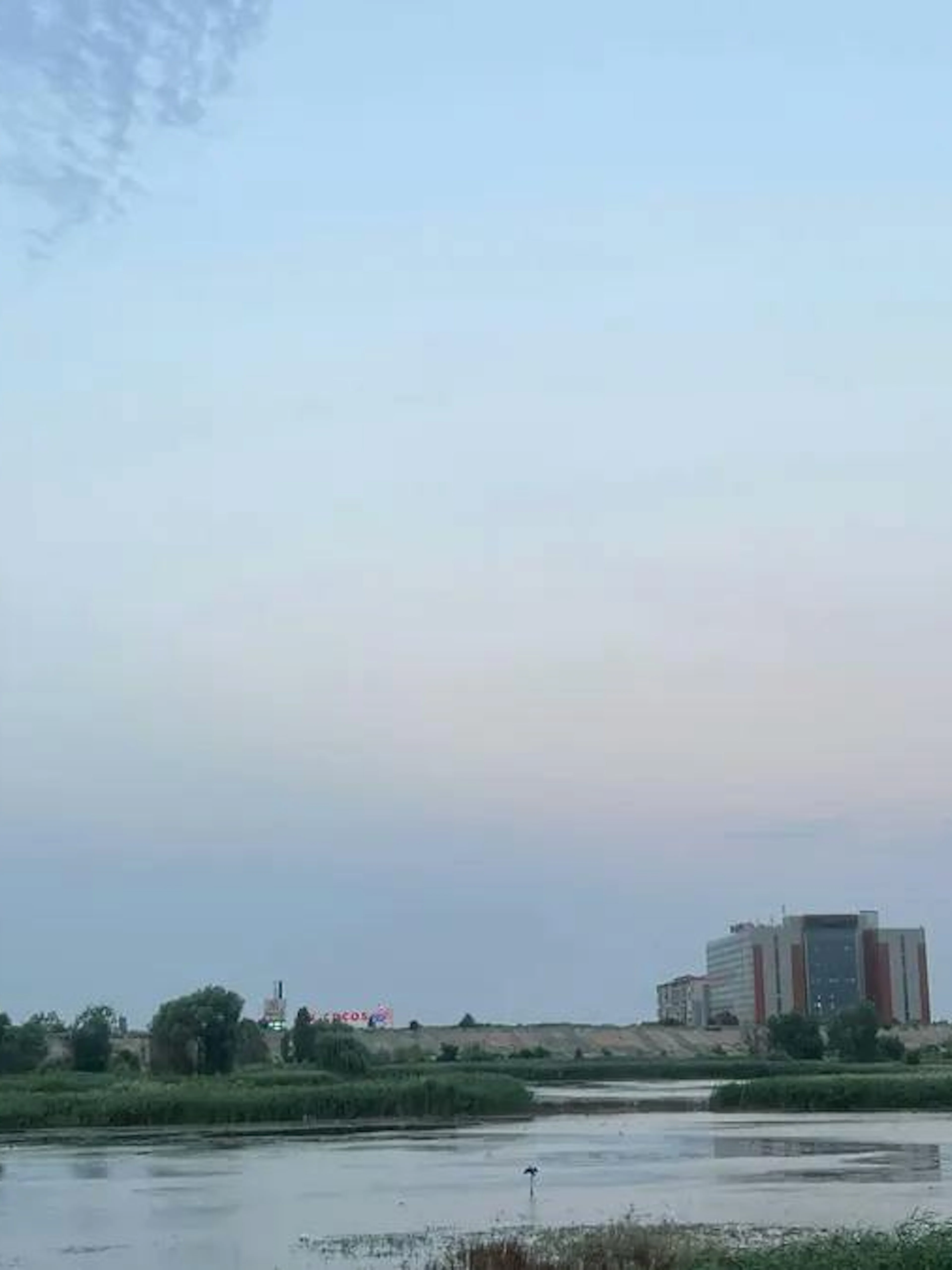 Cretaceous Delta view in Văcărești Nature Park, Bucharest, with distant buildings and greenery.
