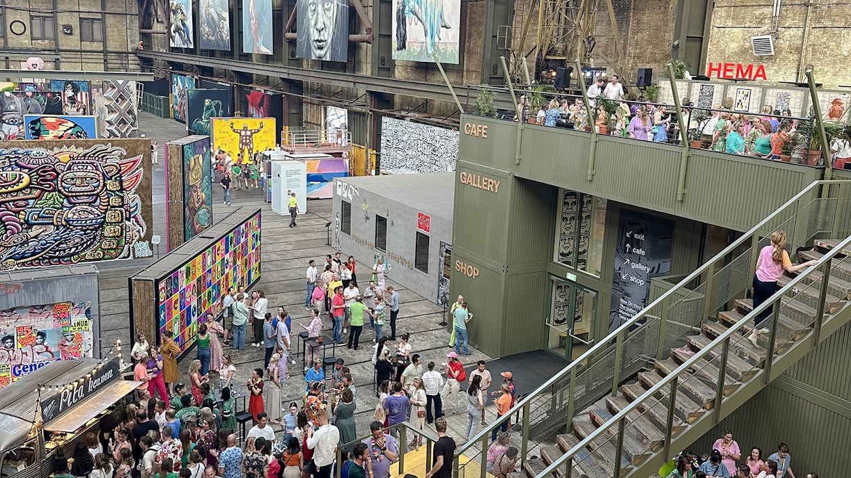 Visitors exploring vibrant street art displays inside Straat Museum, Amsterdam.