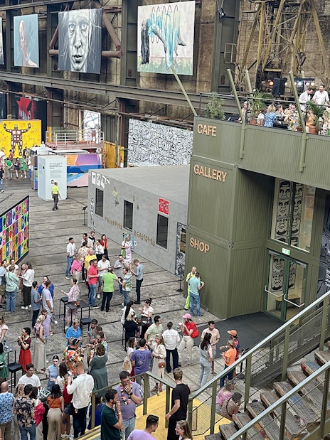 Visitors exploring vibrant street art displays inside Straat Museum, Amsterdam.