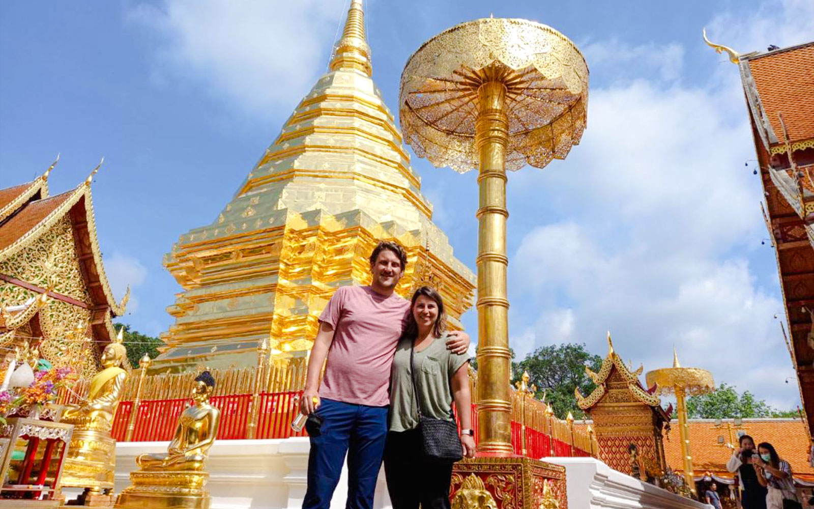Golden pagoda at Wat Phra That Doi Suthep, Chiang Mai, with tourists exploring the temple grounds.