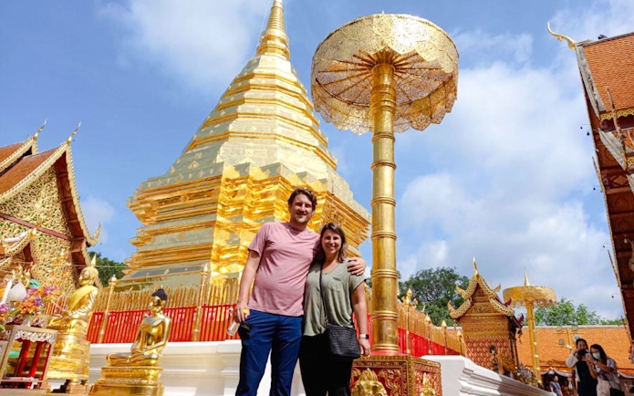 Golden pagoda at Wat Phra That Doi Suthep, Chiang Mai, with tourists exploring the temple grounds.