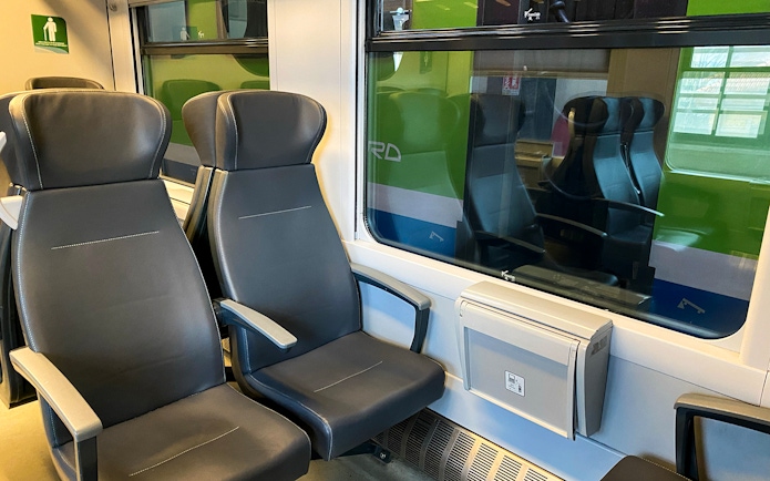 Malpensa Express train interior with empty seats and window view.