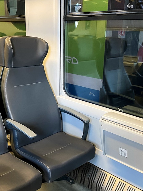 Malpensa Express train interior with empty seats and window view.