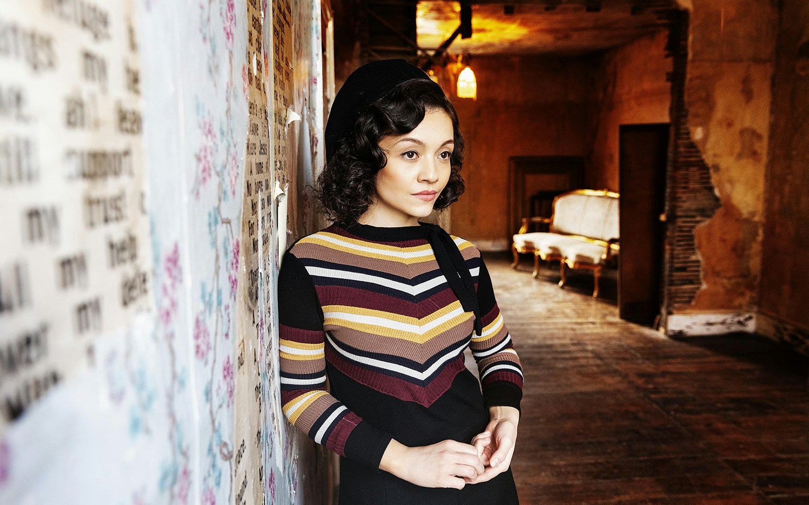 Young woman in vintage attire standing in a rustic room, evoking a Bonnie & Clyde era ambiance.