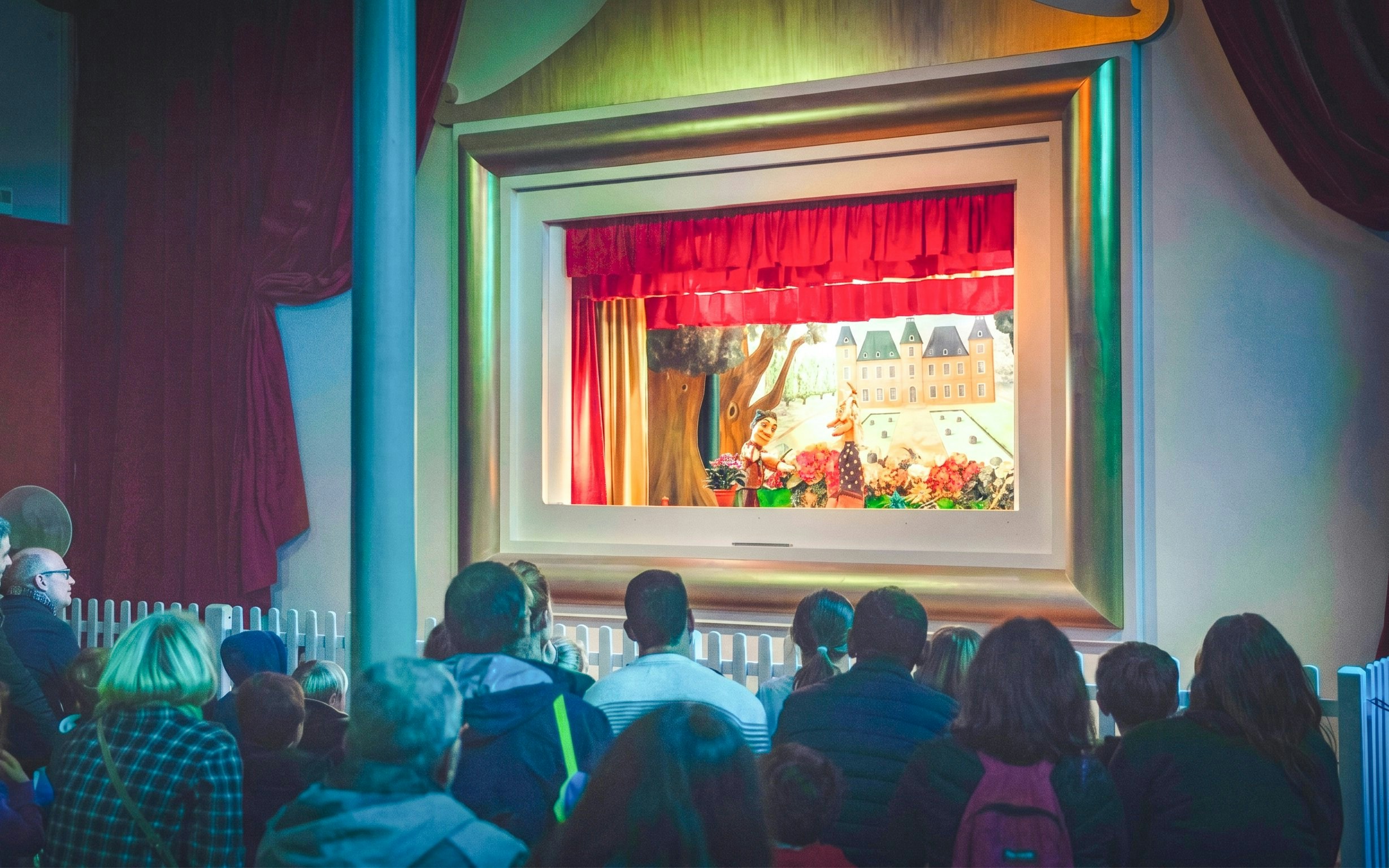 Audience watching Guignol puppet show at Jardin d'Acclimatation, Paris.