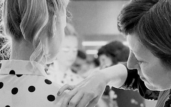 Stylist adjusting polka dot blouse during Barcelona fashion tour.