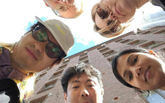 Participants gather for Helsinki Murder Mystery game near a brick building.