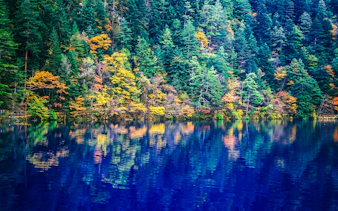 Jiuzhaigou Valley lake with colorful autumn trees reflecting in the water, Chengdu.