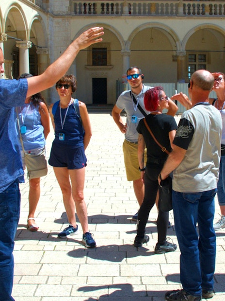 Group listening to a guide at Wawel Castle courtyard, Krakow.