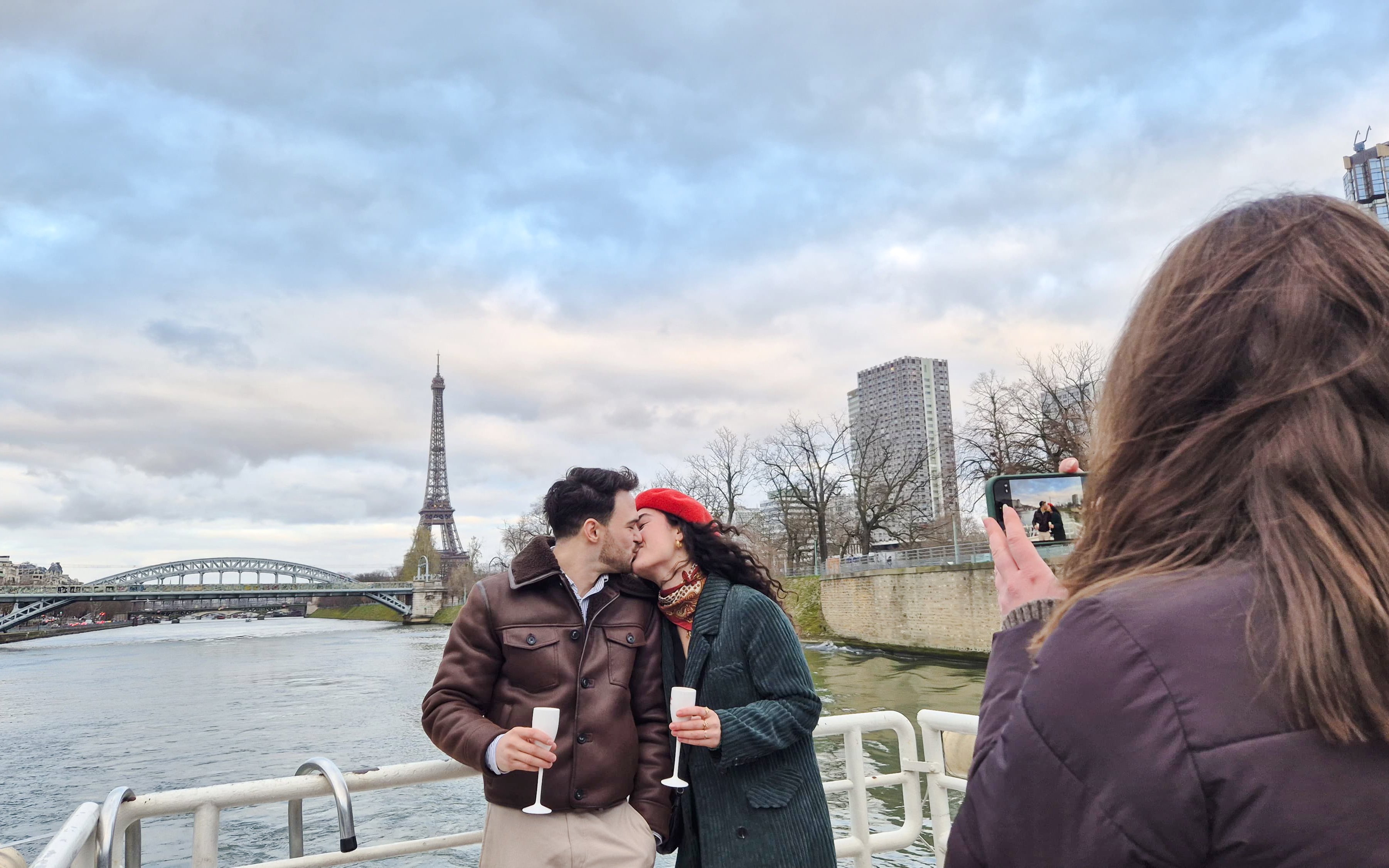 Couple kissing on Seine River cruise with Eiffel Tower in background, Paris, France.
