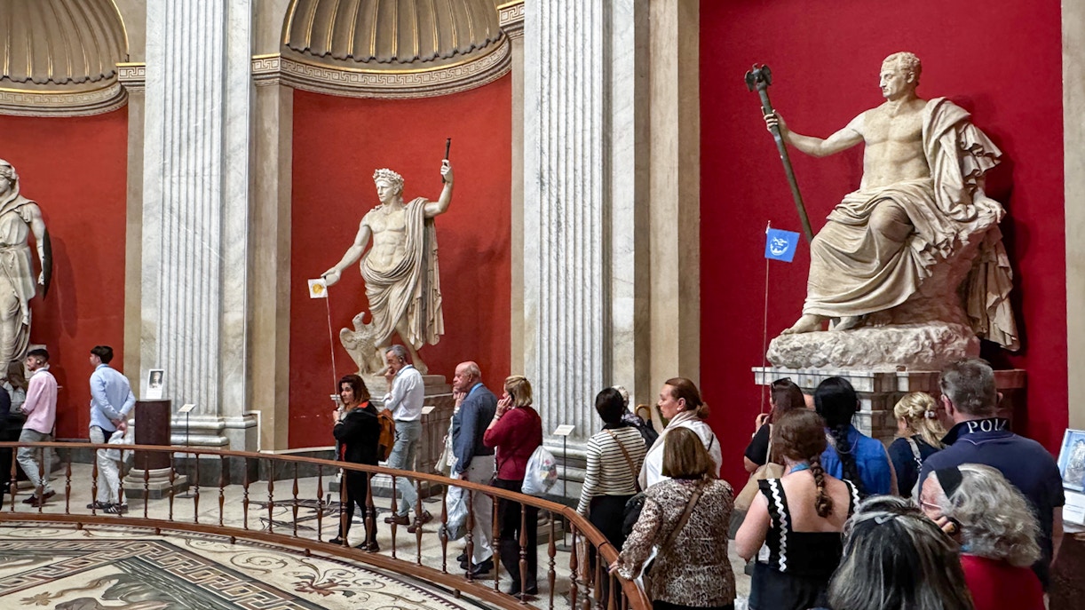 Visitors viewing classical statues in the Round Hall, Vatican Museums, Rome, Italy.